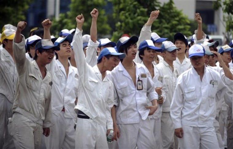 Workers at Foshan Fengfu Autoparts Co., a supply factory to Honda Motor's joint-ventures in China, raise their hands as they strike to demand for higher wages in Foshan in south China's Guangdong province on June 7.